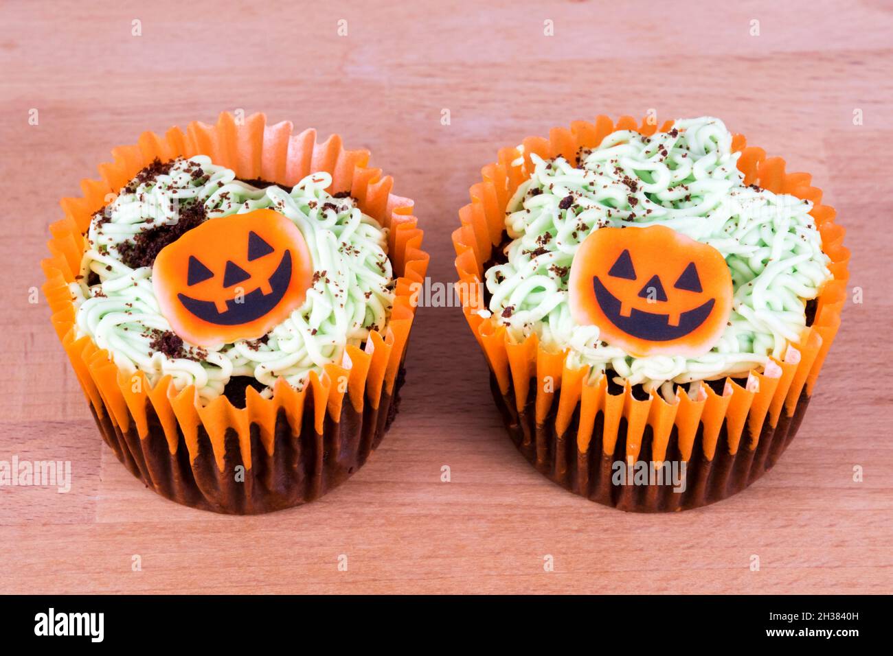 Two Sainsbury's pumpkin patch decorated chocolate cupcakes for Halloween. Stock Photo