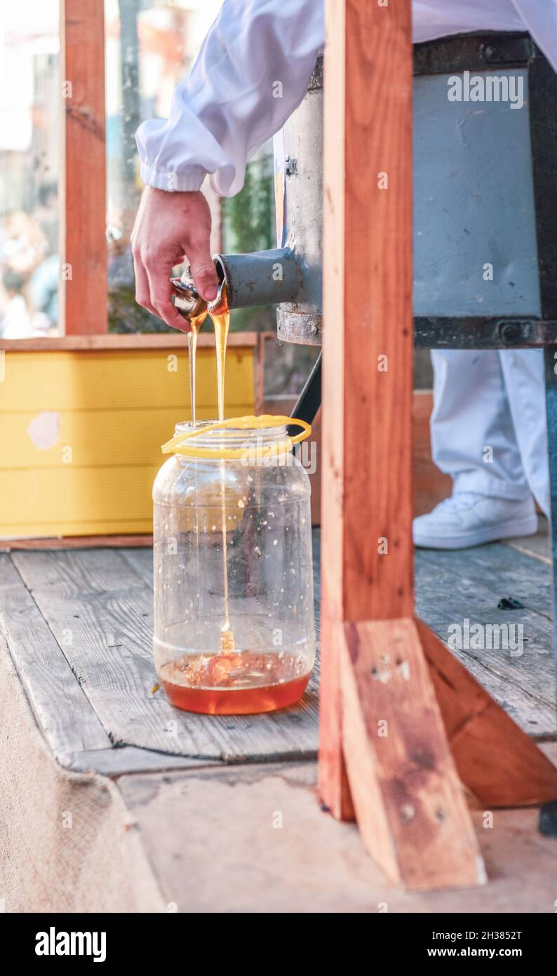 Beekeeper's hand opening the lid of the honey extraction centrifuge