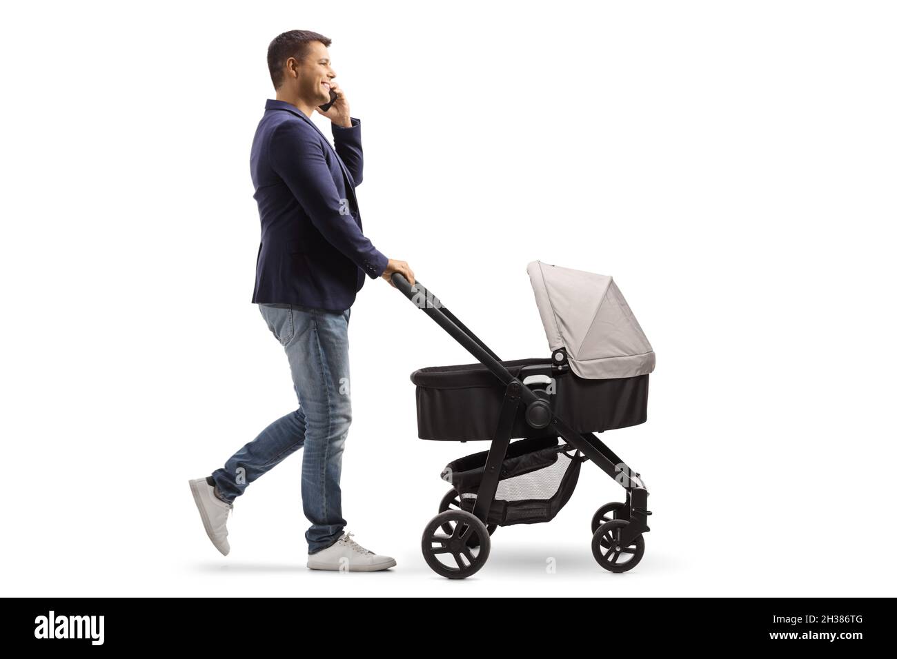 Full length profile shot of a father pushing a baby carriage and making a phone call isolated on white background Stock Photo