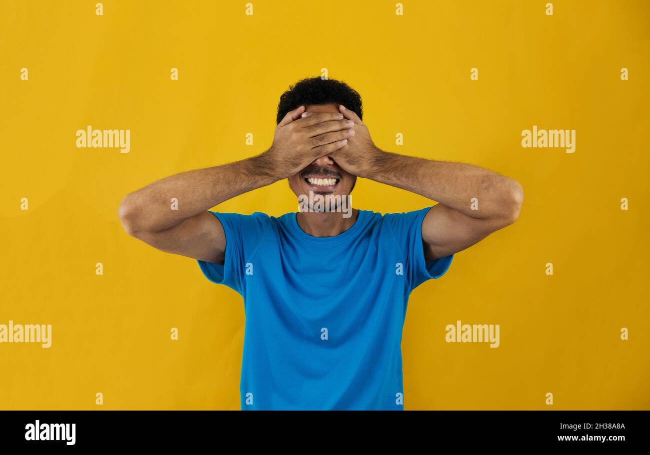 Man covering his eyes isolated on yellow background. Handsome Black Man ...