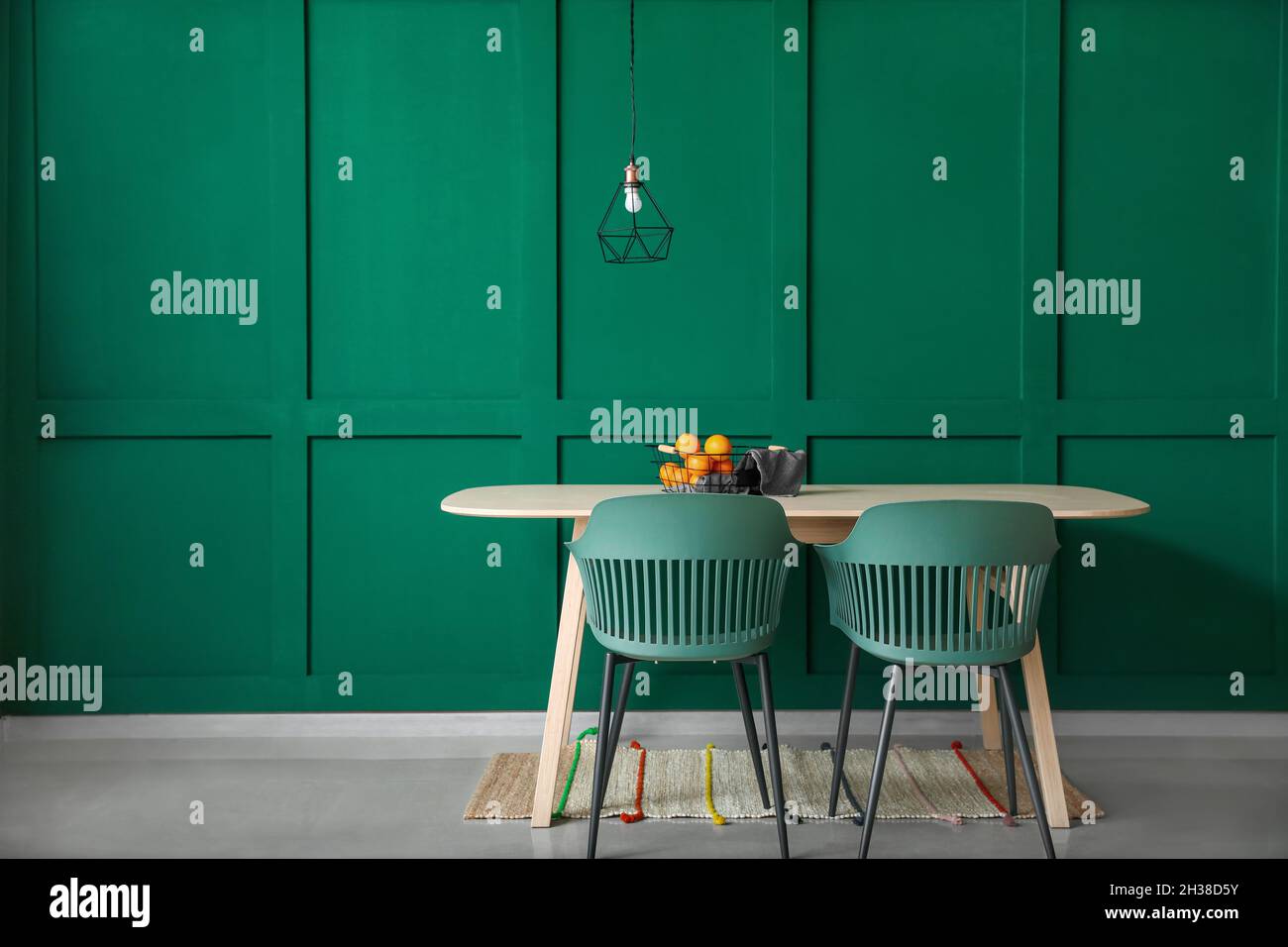 Interior of dining table with basket of fruits near color wall Stock ...