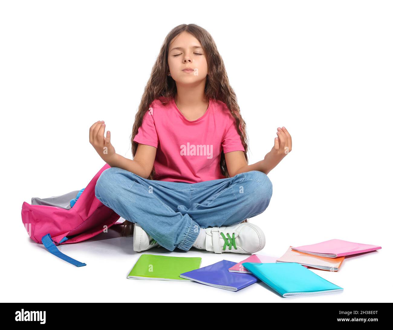 Meditating little schoolgirl isolated on white Stock Photo