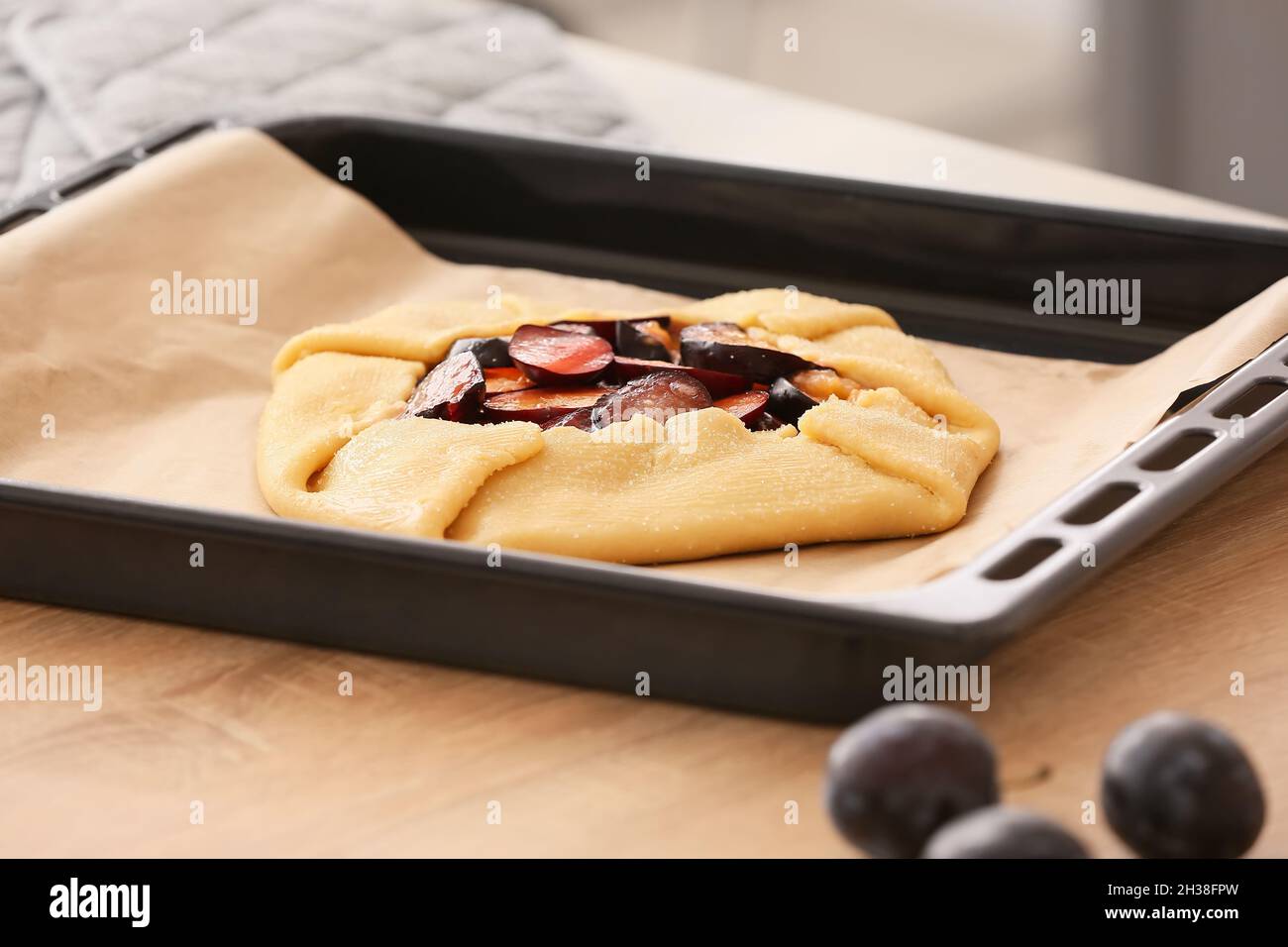 Baking tray with uncooked plum galette on table, closeup Stock Photo