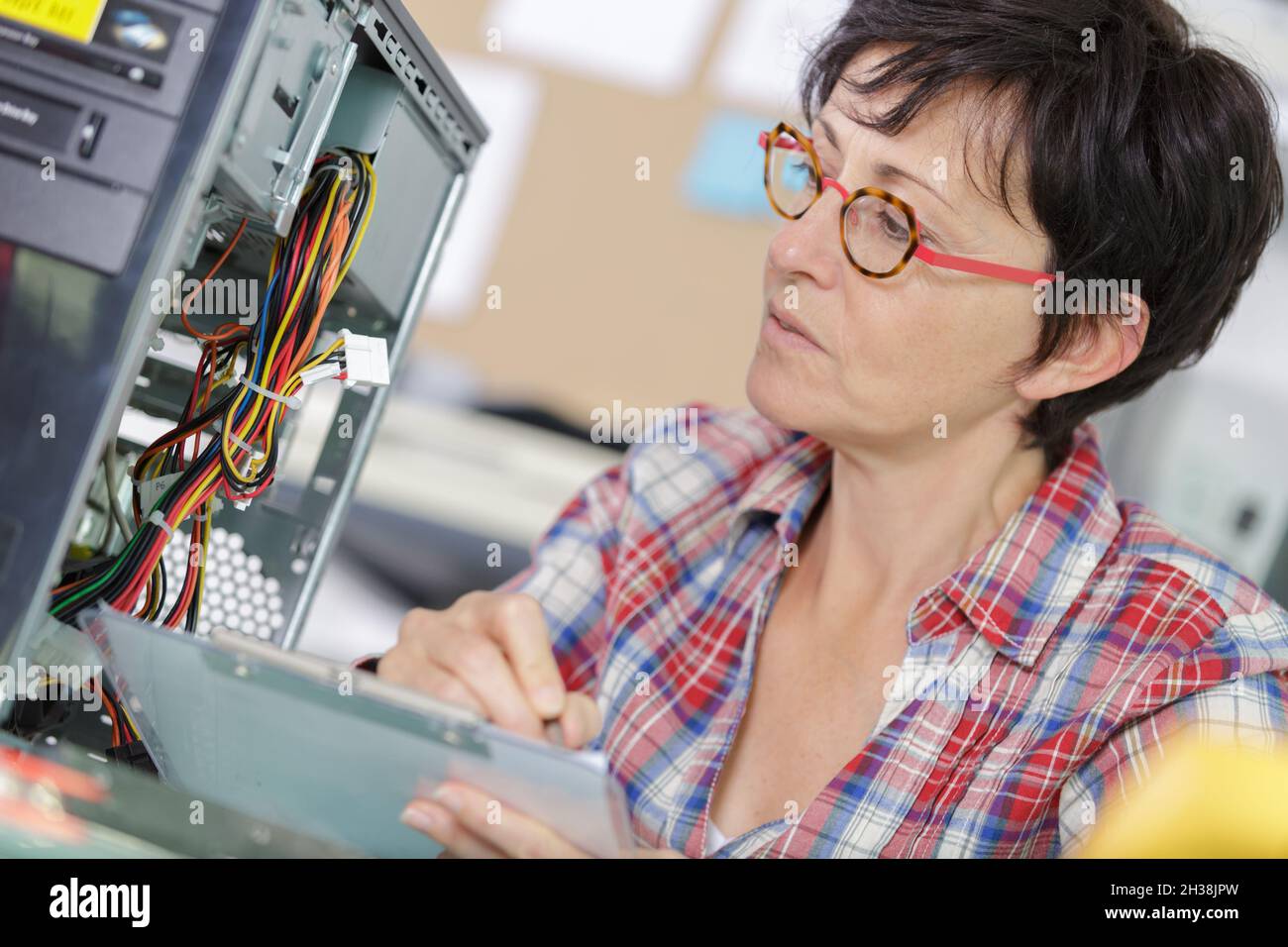 mature engineer with clipboard in server room Stock Photo