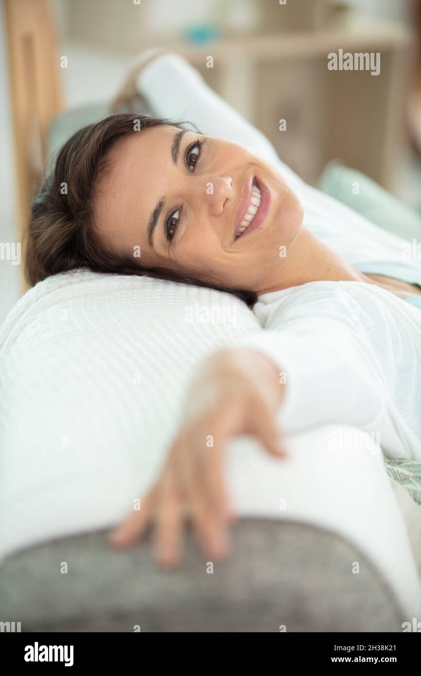 closeup of a smiling young woman lying on couch Stock Photo - Alamy
