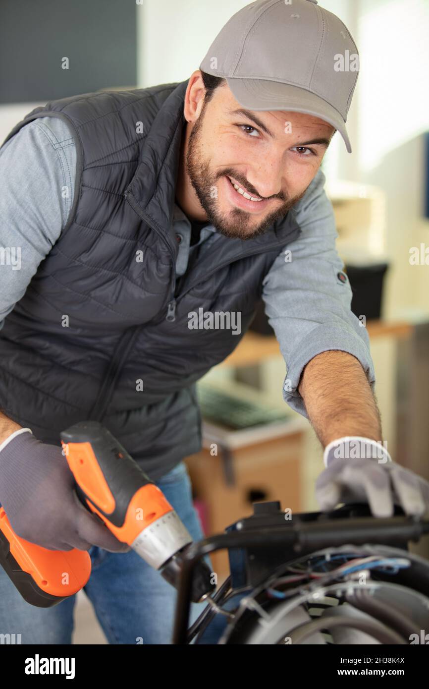 male technician using a cordless screwdriver Stock Photo