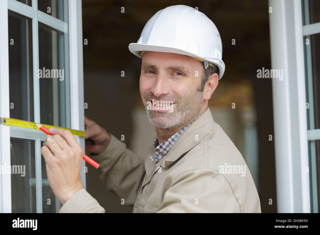 workman measuring double glazed window Stock Photo