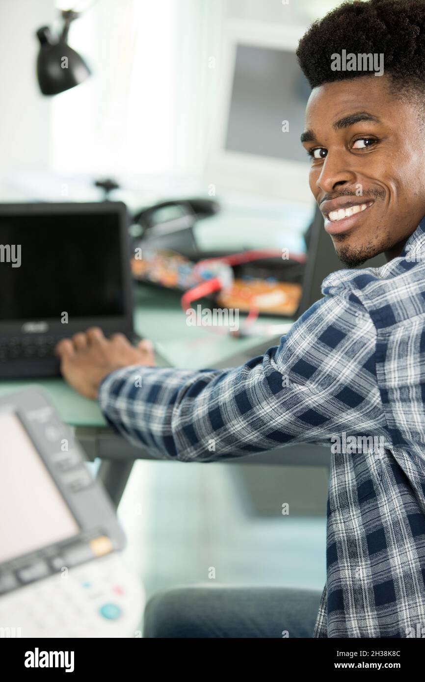 young male contractor repairing computer Stock Photo