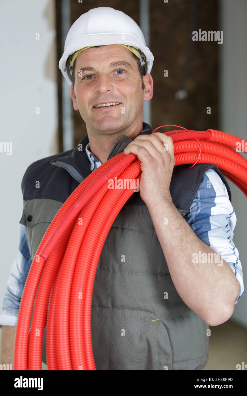 happy electrician with red wires on a construction site Stock Photo