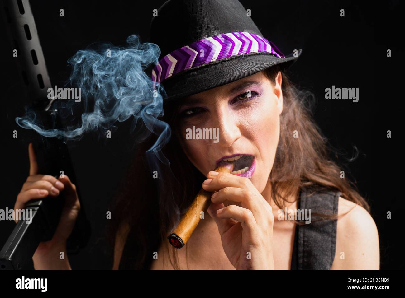 Intimidating White woman from the US smoking a cigar holding a gun wearing makeup and a hat