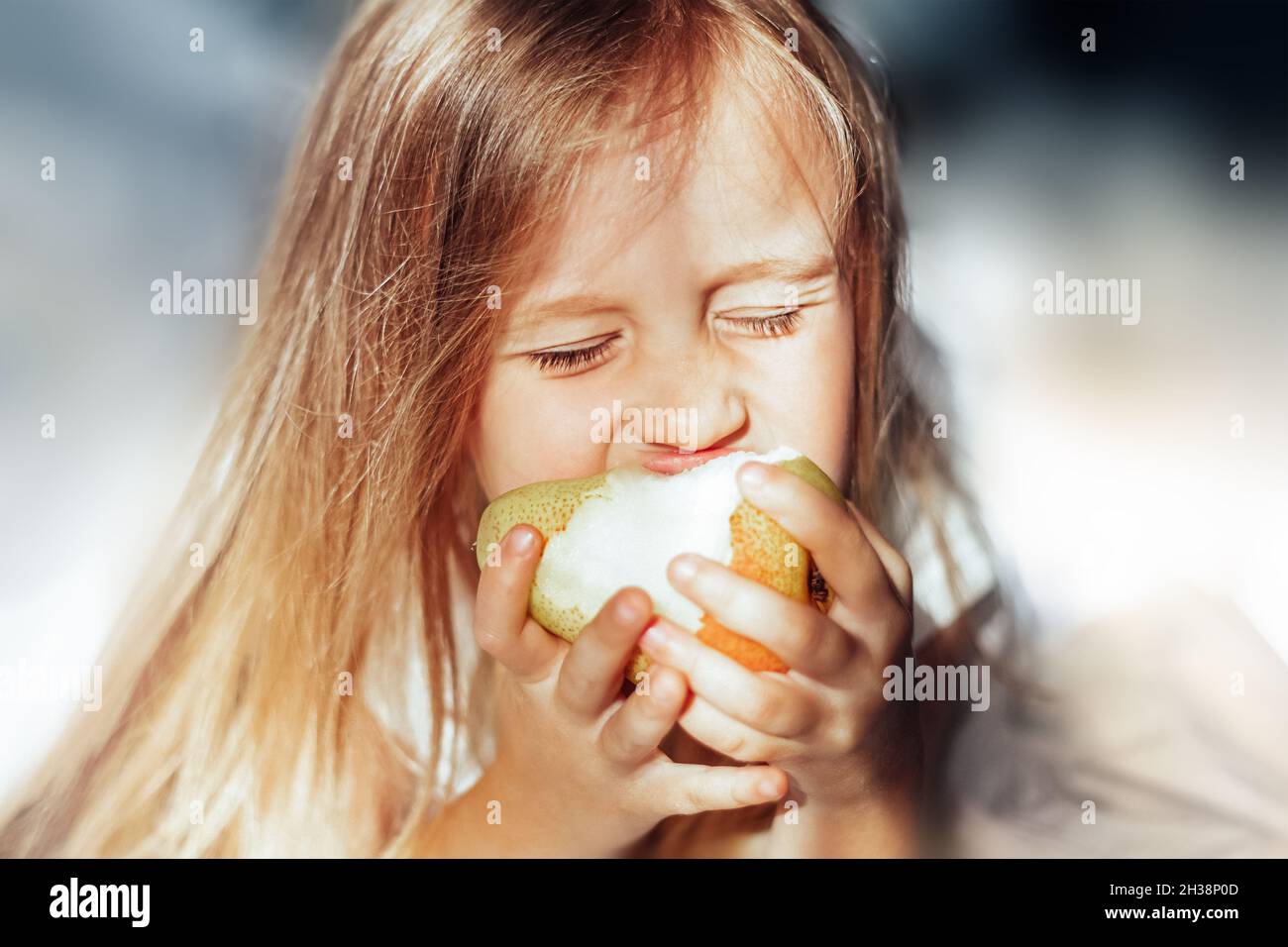 Girl in the morning eating a pear in bed Stock Photo Alamy