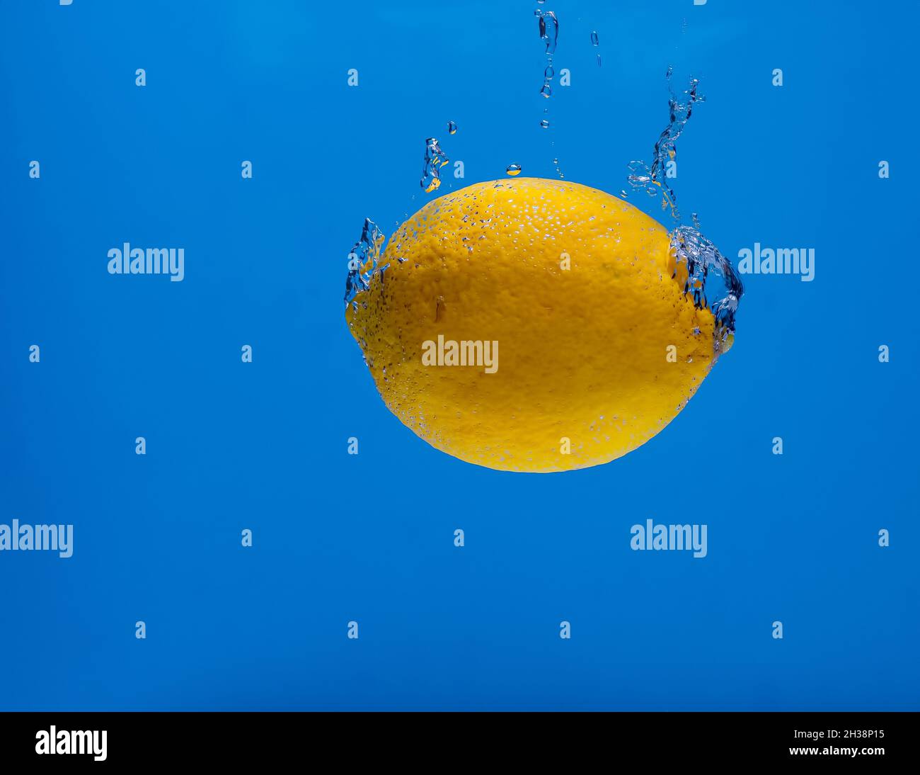 lemon with water bubbles on a blue background Stock Photo
