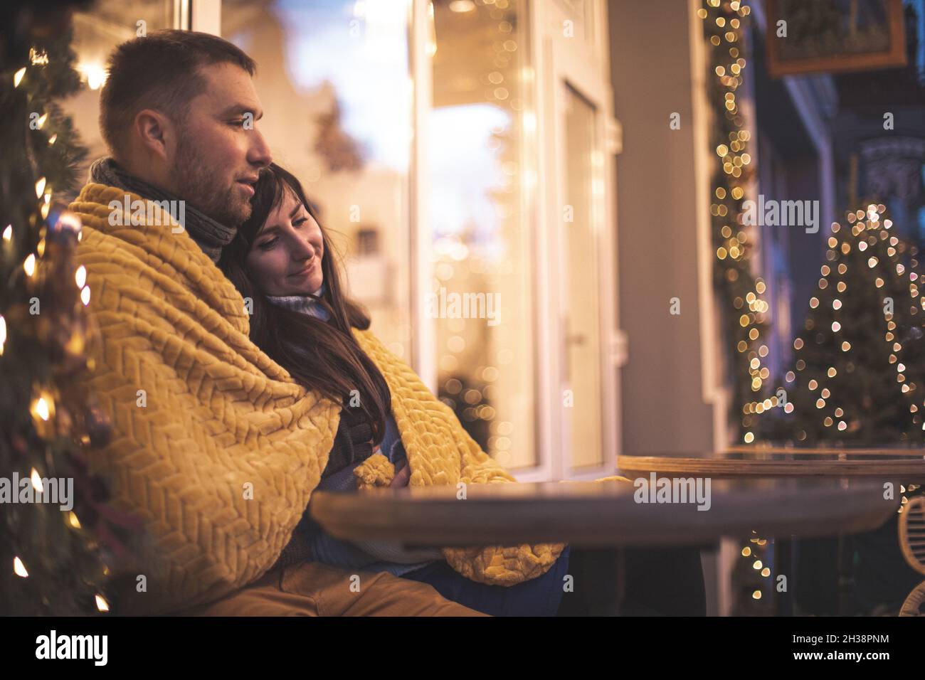 Romantic couple sitting at the sofa at the outdoor cafe Stock Photo