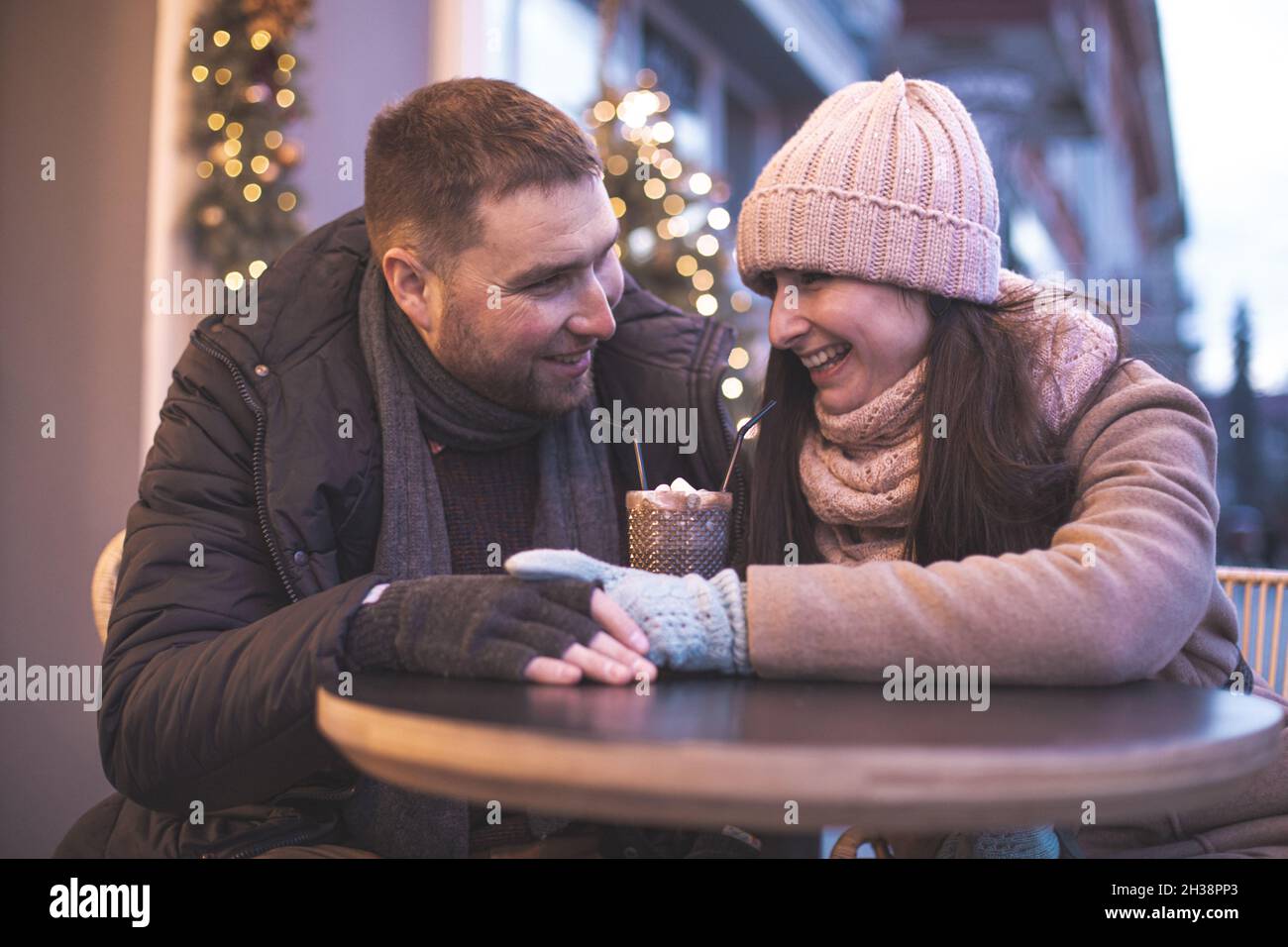 Romantic couple sitting at the table at the outdoor cafe Stock Photo