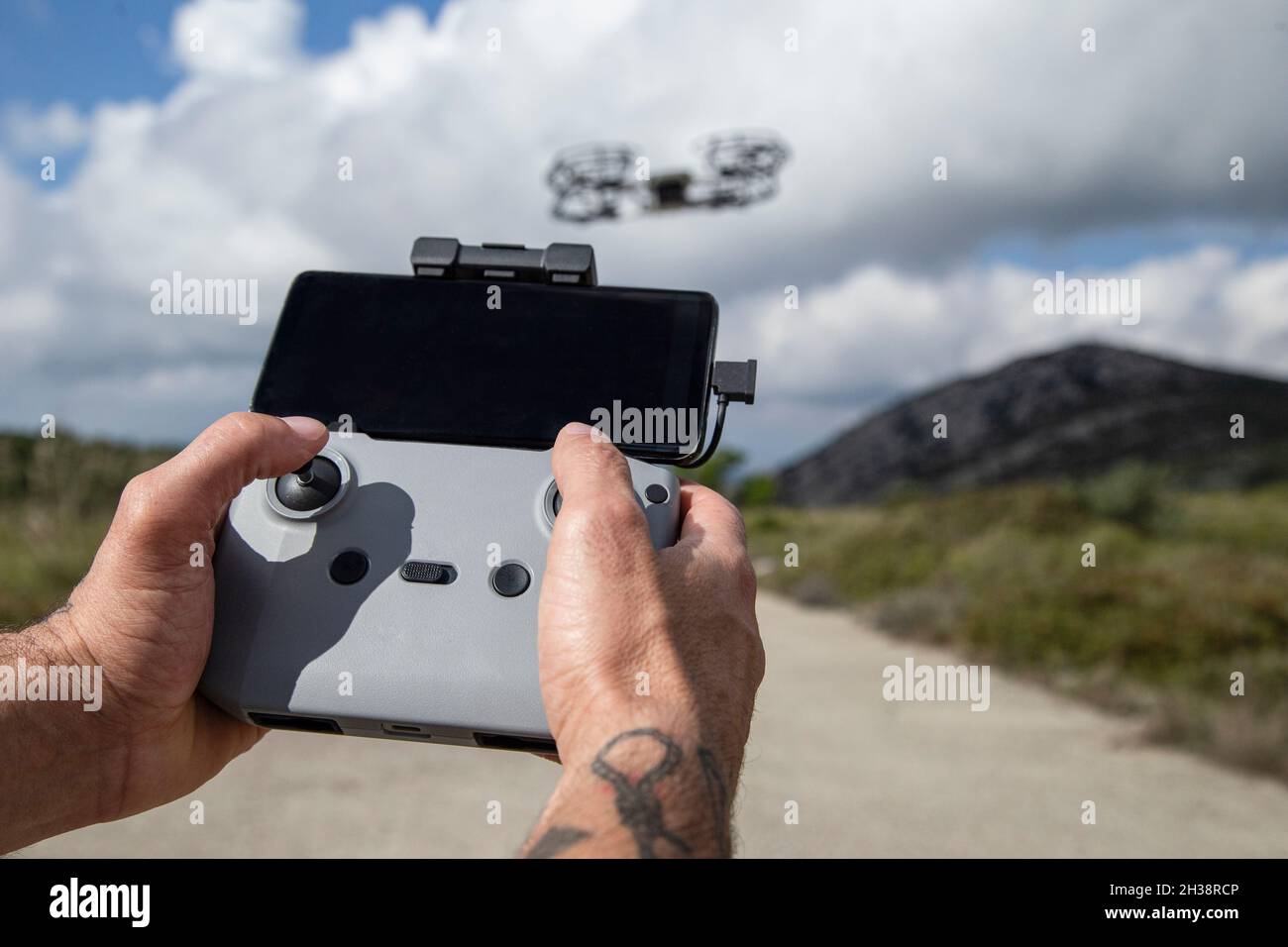 Man's hands operating the remote control of the unmanned drone Stock Photo