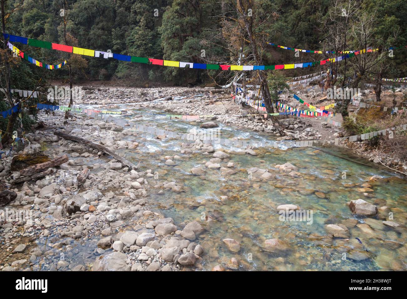 Traditional prayer Tibetan Buddhist flags Lung Ta over the river in Bhutan in the Thimphu River valley. Stock Photo