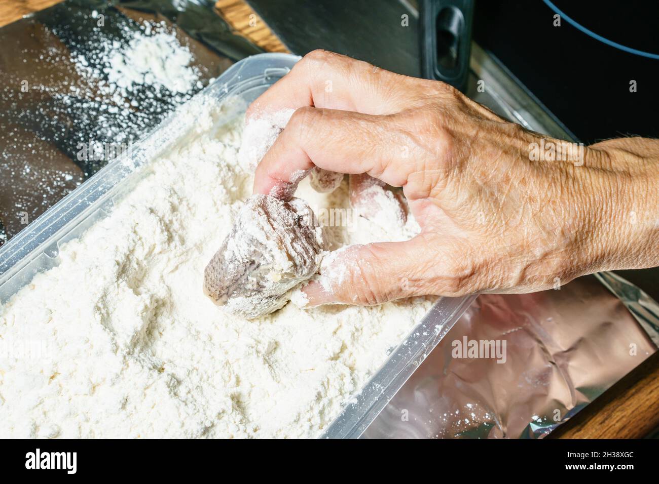 Man preparing fish for frying Stock Photo - Alamy