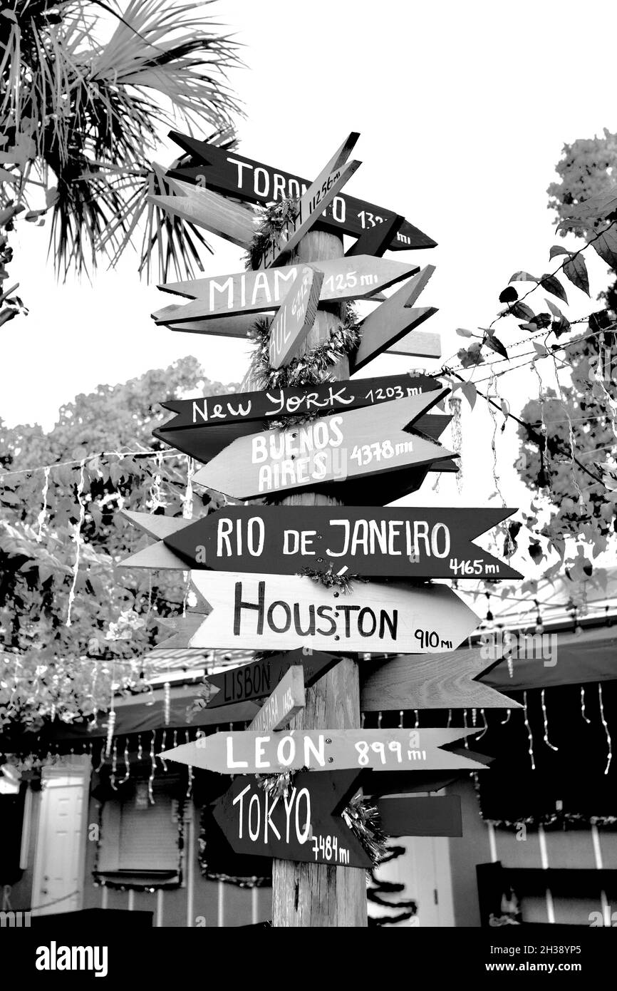 Directional Arrow sign to various places around the world.  Made out of wooden arrows on sign post.  Each city name has the miles from Key West, FL Stock Photo