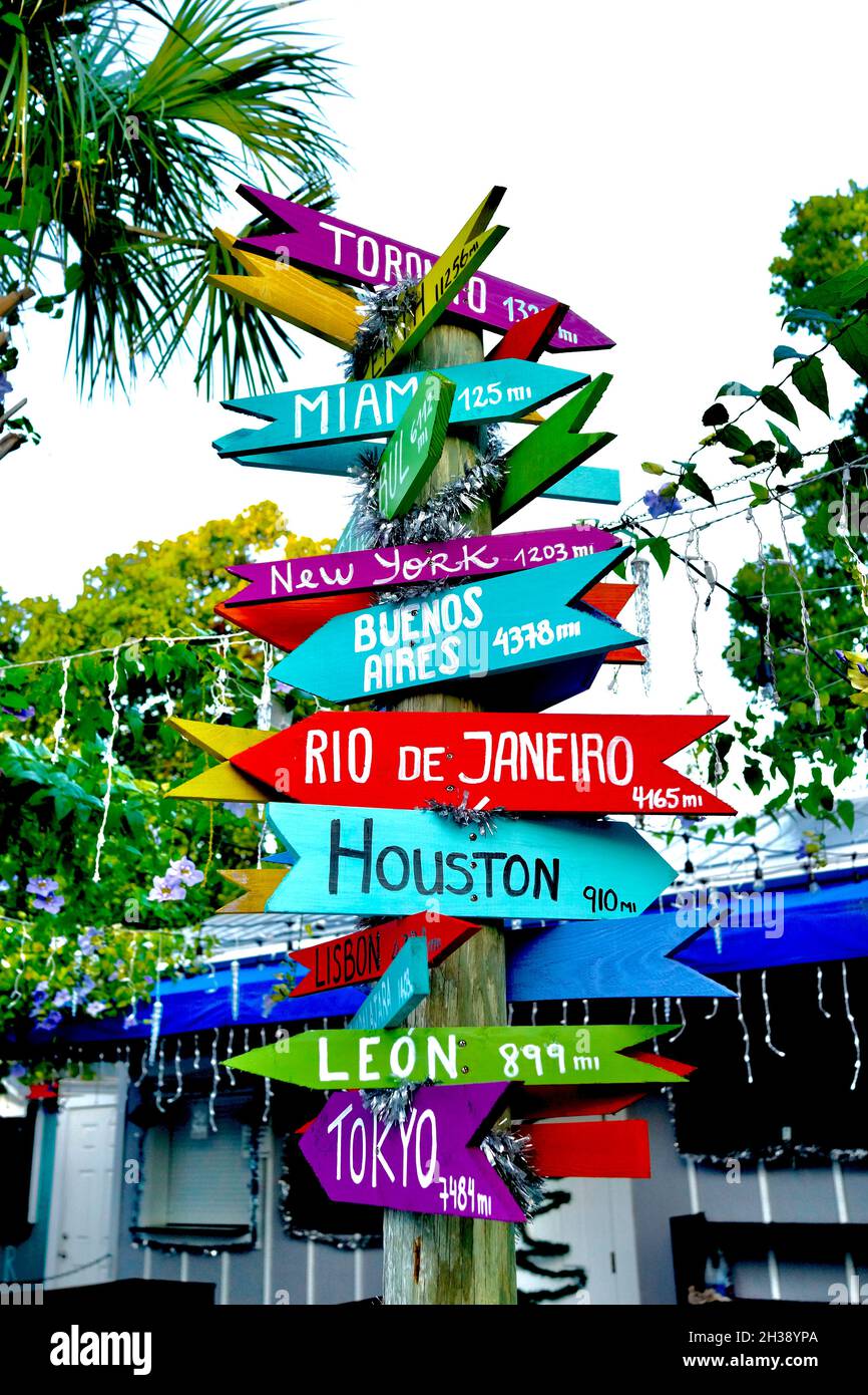 Directional Arrow sign to various places around the world.  Made out of wooden arrows on sign post.  Each city name has the miles from Key West, FL Stock Photo