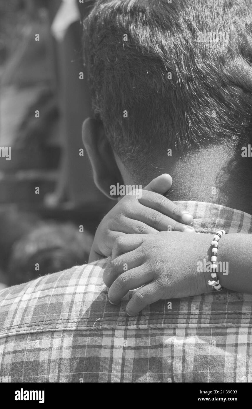 Father's back with daughter's arms around his neck. Vintage effect, black and white photography Stock Photo