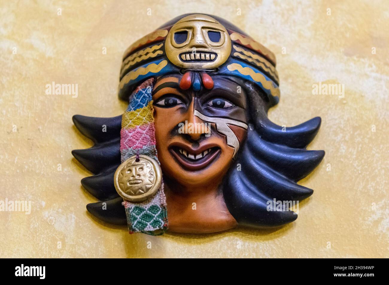 Artistic face mask of an Inca woman decorates the wall. Cuzco, Peru. Stock Photo
