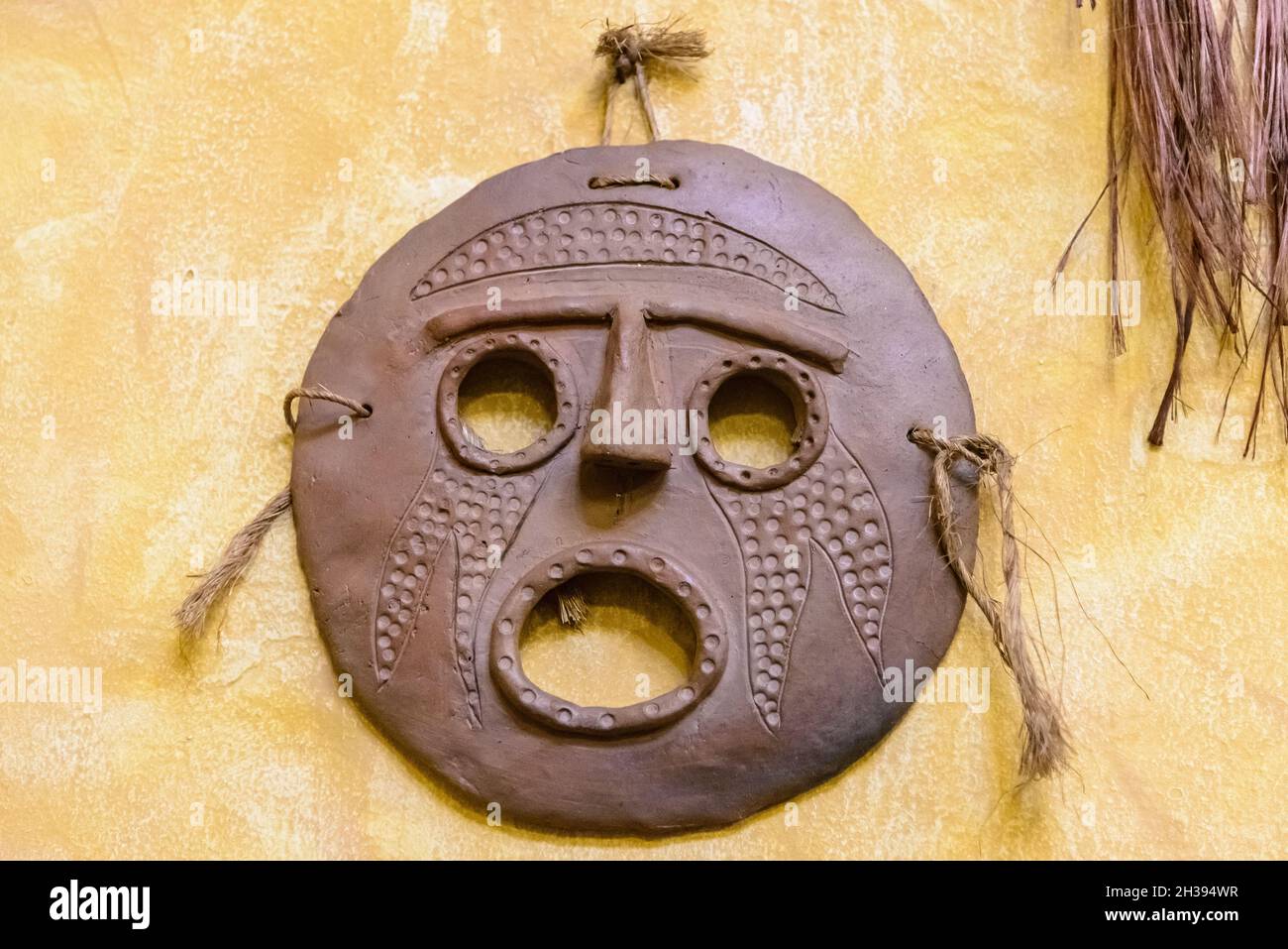 Native clay face mask decorates the wall. Cuzco, Peru. Stock Photo