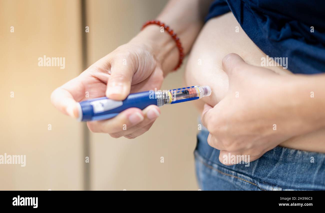 The diabetic patient hand using the insulin pen injection medical equipment to check and control