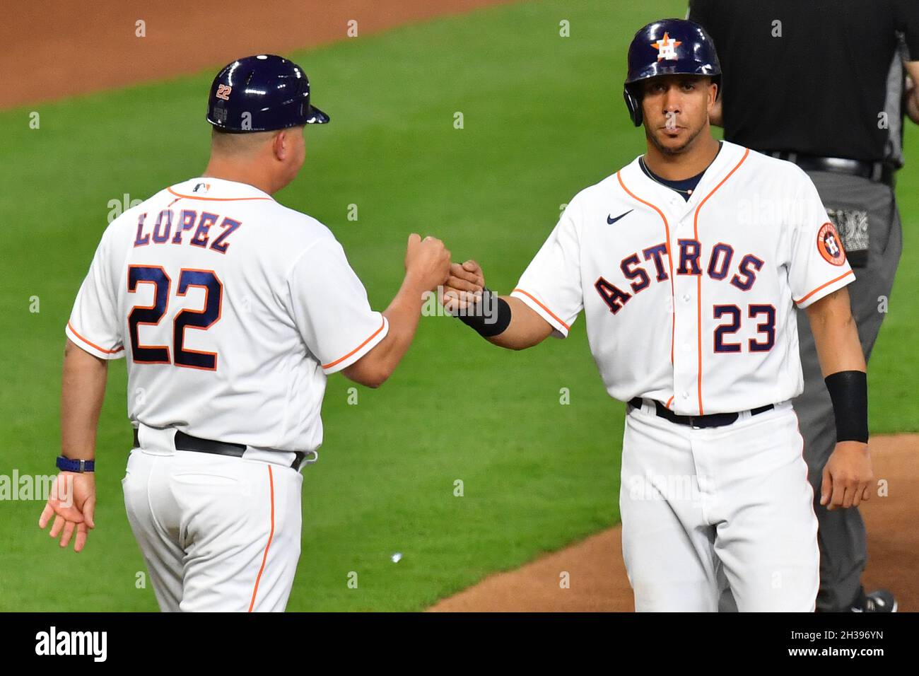 Houston, United States. 26th Oct, 2021. Houston Astros Michael Brantley is  congratulated by third base coach Omar Lopez after advancing on a wild  pitch in the 1st inning of game one against
