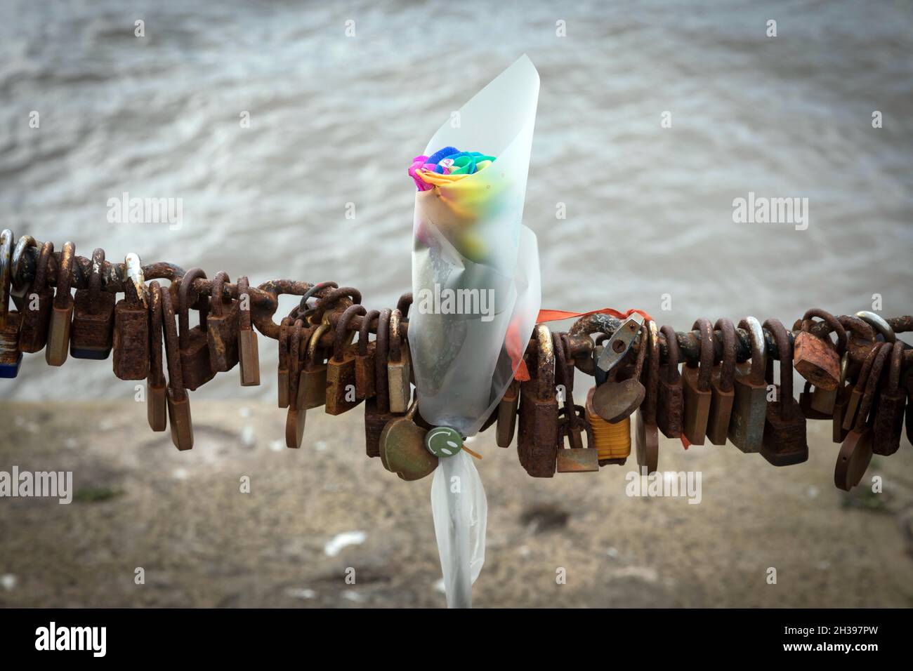 A floral tribute and padlocks on a chain at the Waterfront, Liverpool Stock Photo