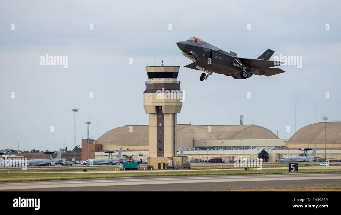 With the Tinker control tower in the background, an F-35 Lightning II aircraft takes off at Tinker Air Force Base, Oklahoma, Oct. 22, 2021. The Oklahoma City Air Logistics Complex's Heavy Maintenance Center performs all aspects of engine maintenance on the F135 engine, including all variants and for all partner nations. (U.S. Air Force photo by Paul Shirk) Stock Photo
