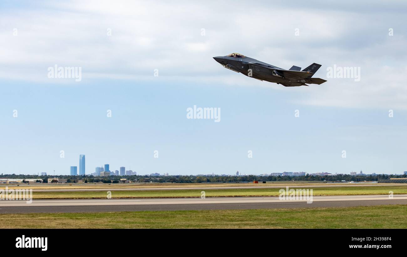 An F-35 Lightning II aircraft takes off against the background of the Oklahoma City skyline at Tinker Air Force Base, Oklahoma, Oct. 22, 2021. Twelve F-35s stopped at Tinker AFB to refuel while en route from Tyndall AFB, Florida, to Hill AFB, Utah. The Oklahoma City Air Logistics Complex's Heavy Maintenance Center performs all aspects of engine maintenance on the F135 engine, which powers the F-35. (U.S. Air Force photo by Paul Shirk) Stock Photo