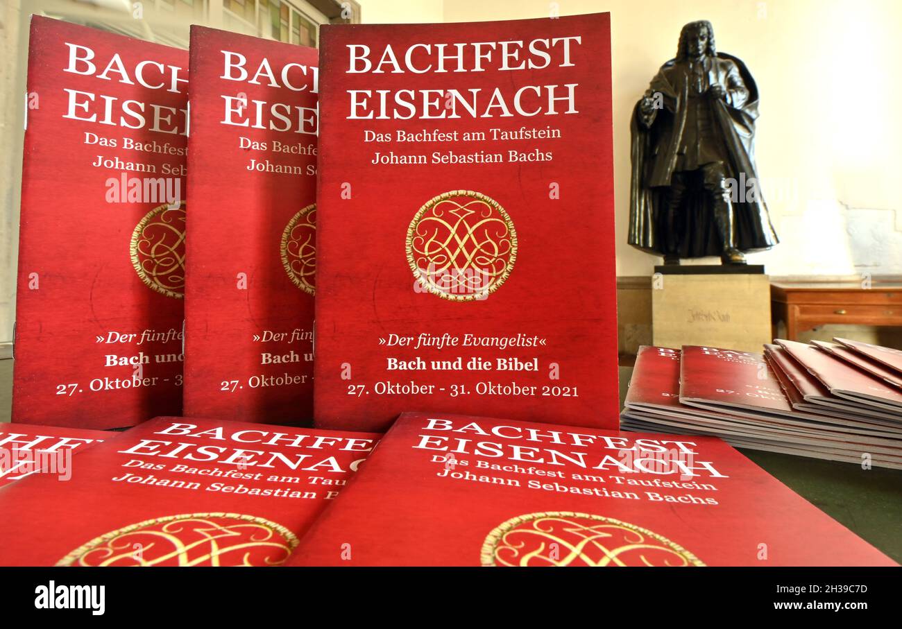 Eisenach, Germany. 25th Oct, 2021. Programme booklets with the inscription 'Bachfest Eisenach' can be found next to Bach's bronze statue in the Georgenkirche, the church where Johann Sebastian Bach was baptised. The 5th Eisenach Bach Festival will take place from 27 October to 31 October under the motto 'The Fifth Evangelist - Bach and the Bible'. Credit: Martin Schutt/dpa-Zentralbild/dpa/Alamy Live News Stock Photo