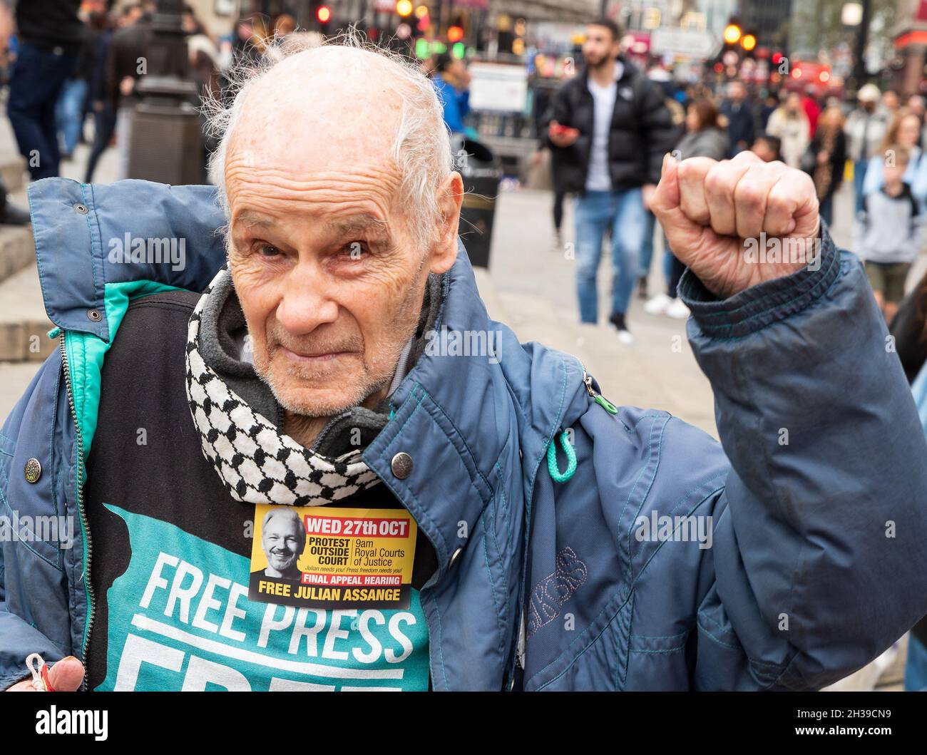 Piccadilly Circus, London, UK. 23rd October 2021. Supporters of WikiLeaks founder Julian Assange protest at London’s Piccadilly Circus prior to Julian being brought from Belmarsh Prison to appear at London’s High Court at the Royal Courts of Justice on the 27th October 2021 for an extradition appeal. Assange supporter wearing Free Assange Free Press shirt and displaying Assange Final Appeal sticker. Credit: Stephen Bell/Alamy Stock Photo