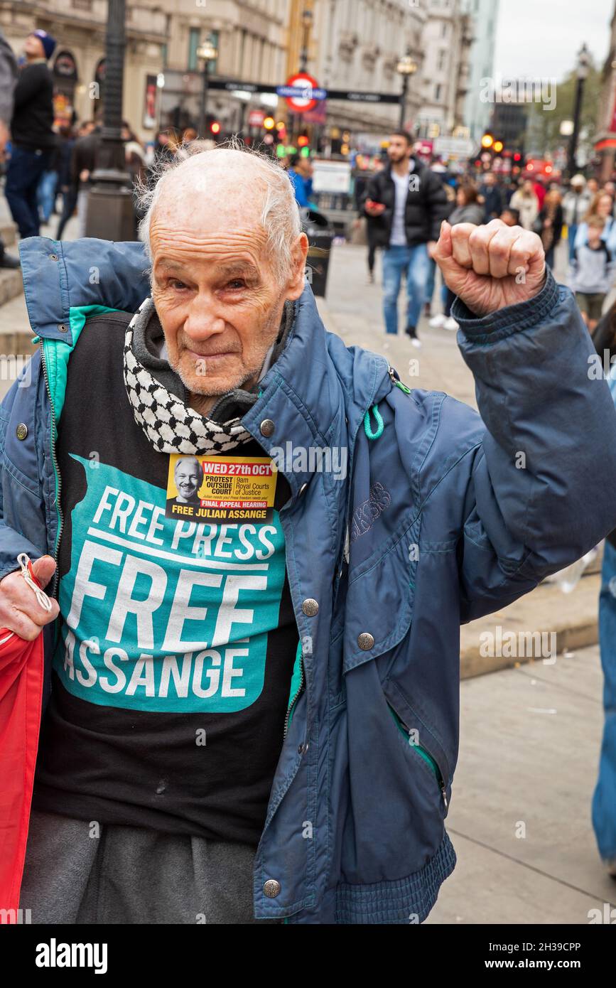 Piccadilly Circus, London, UK. 23rd October 2021. Supporters of WikiLeaks founder Julian Assange protest at London’s Piccadilly Circus prior to Julian being brought from Belmarsh Prison to appear at London’s High Court at the Royal Courts of Justice on the 27th October 2021 for an extradition appeal. Assange supporter wearing Free Assange Free Press shirt and displaying Assange Final Appeal sticker. Credit: Stephen Bell/Alamy Stock Photo