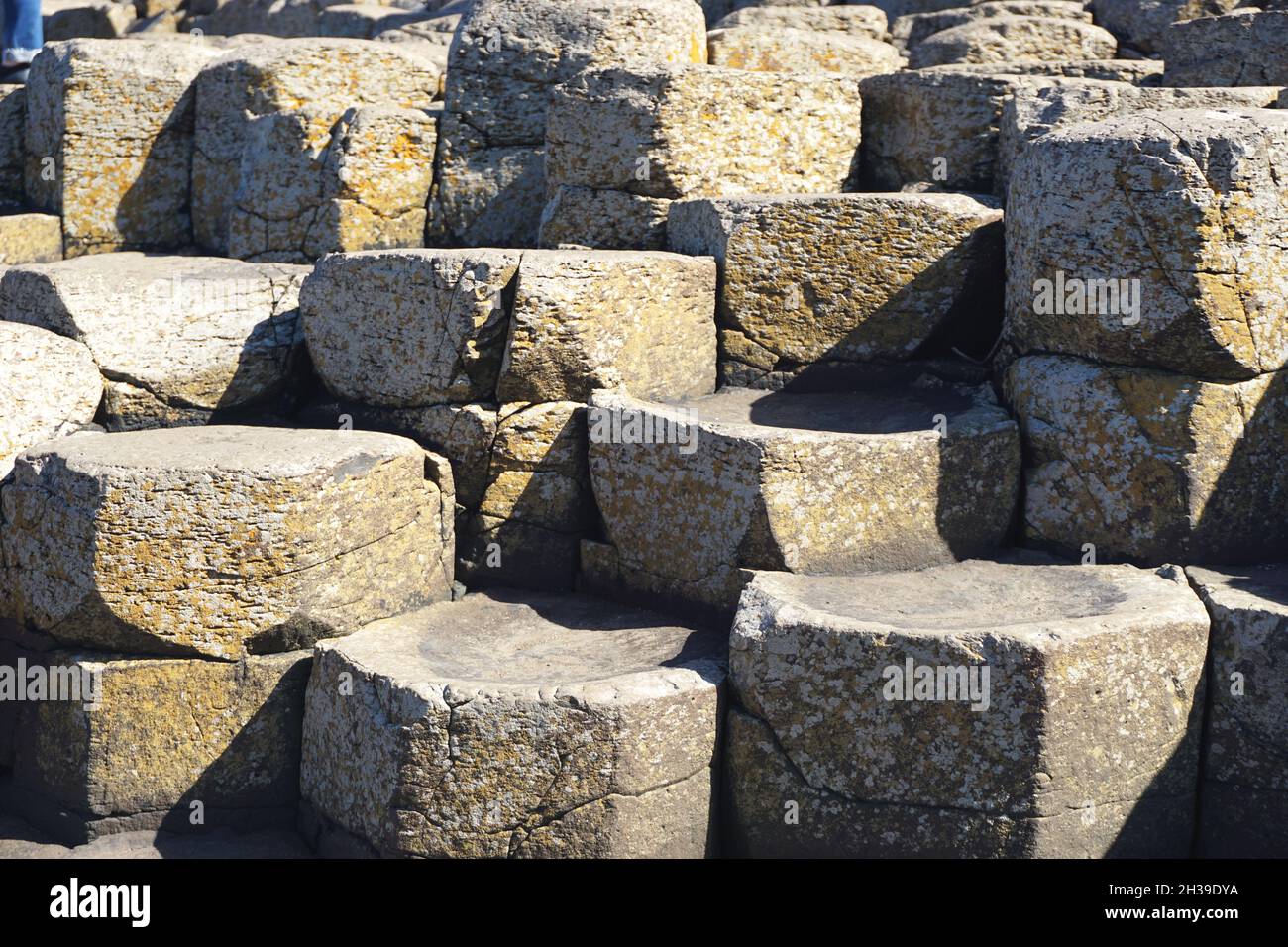 Closeup of natural volcanic rock formations with geometric shapes at the Giant’s Causeway, in County Antrim on the north coast of Northern Ireland. Stock Photo