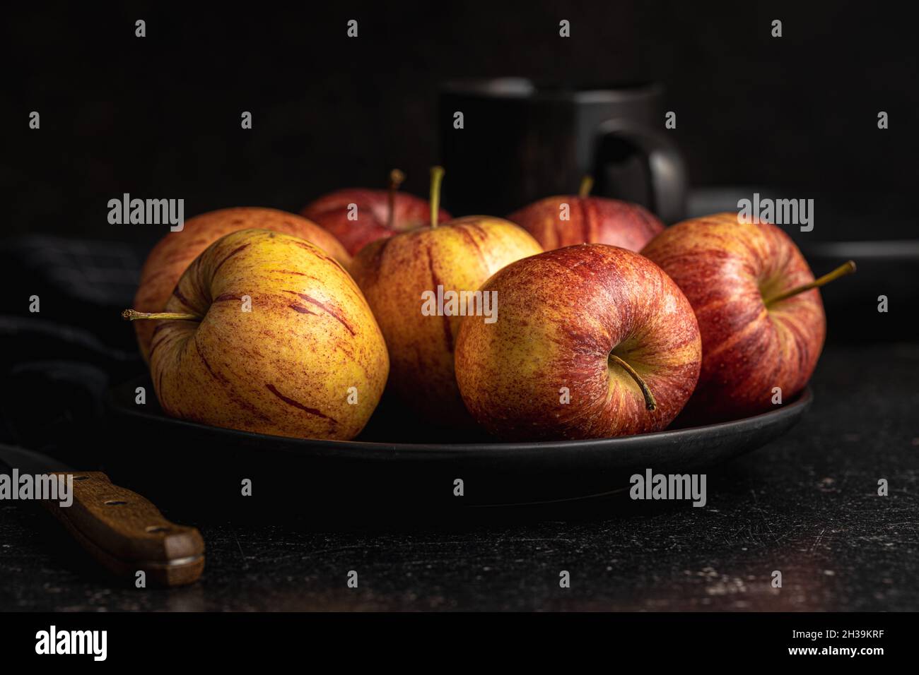 Fresh autumn apples on plate on black table. Stock Photo