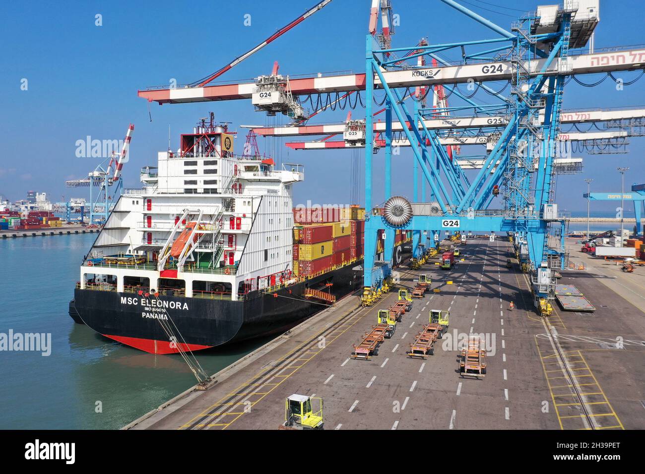 Port work environment and a truck loaded with an MSC Container crossing the frame Stock Photo