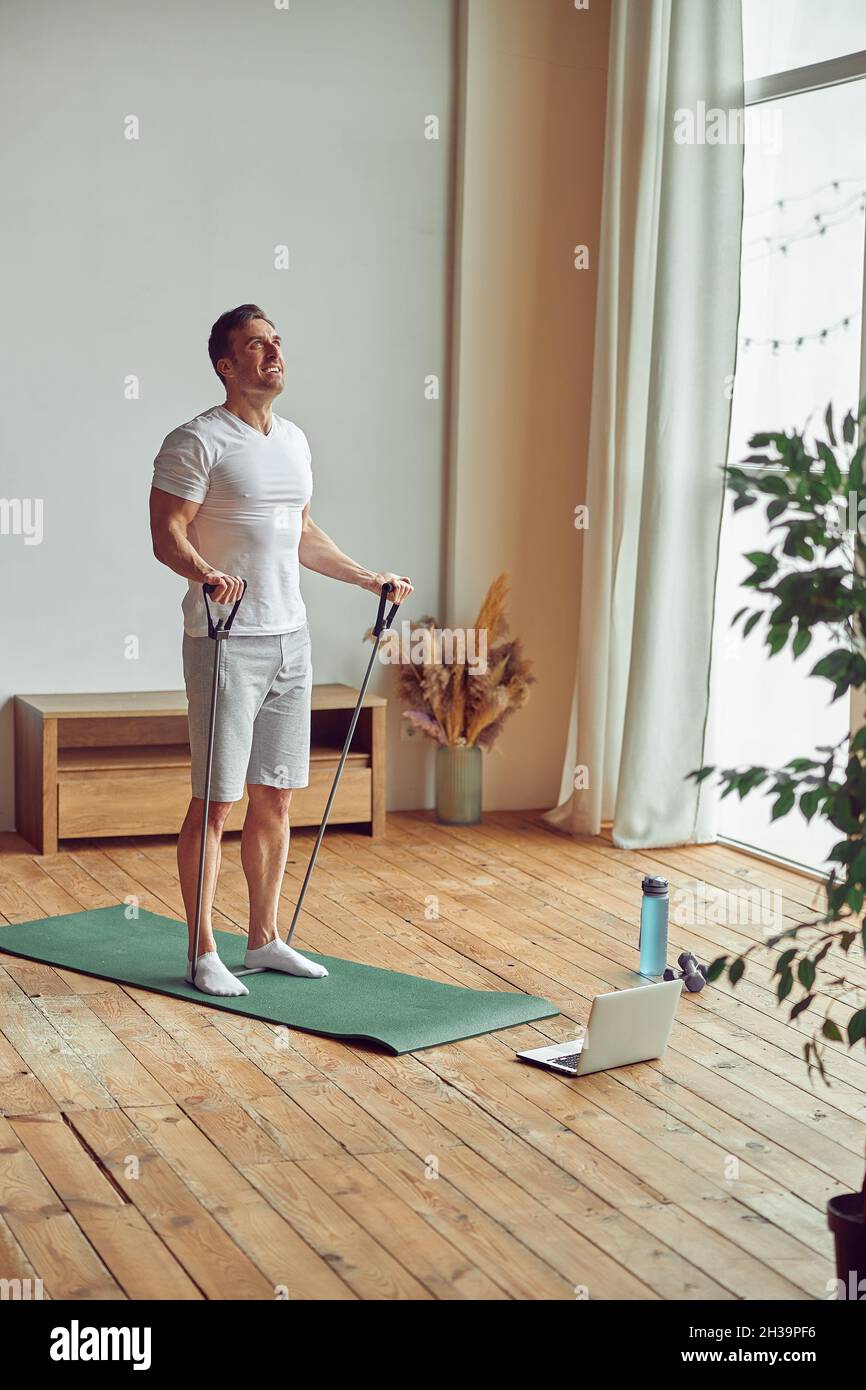 Strong man using resistance bands at home Stock Photo