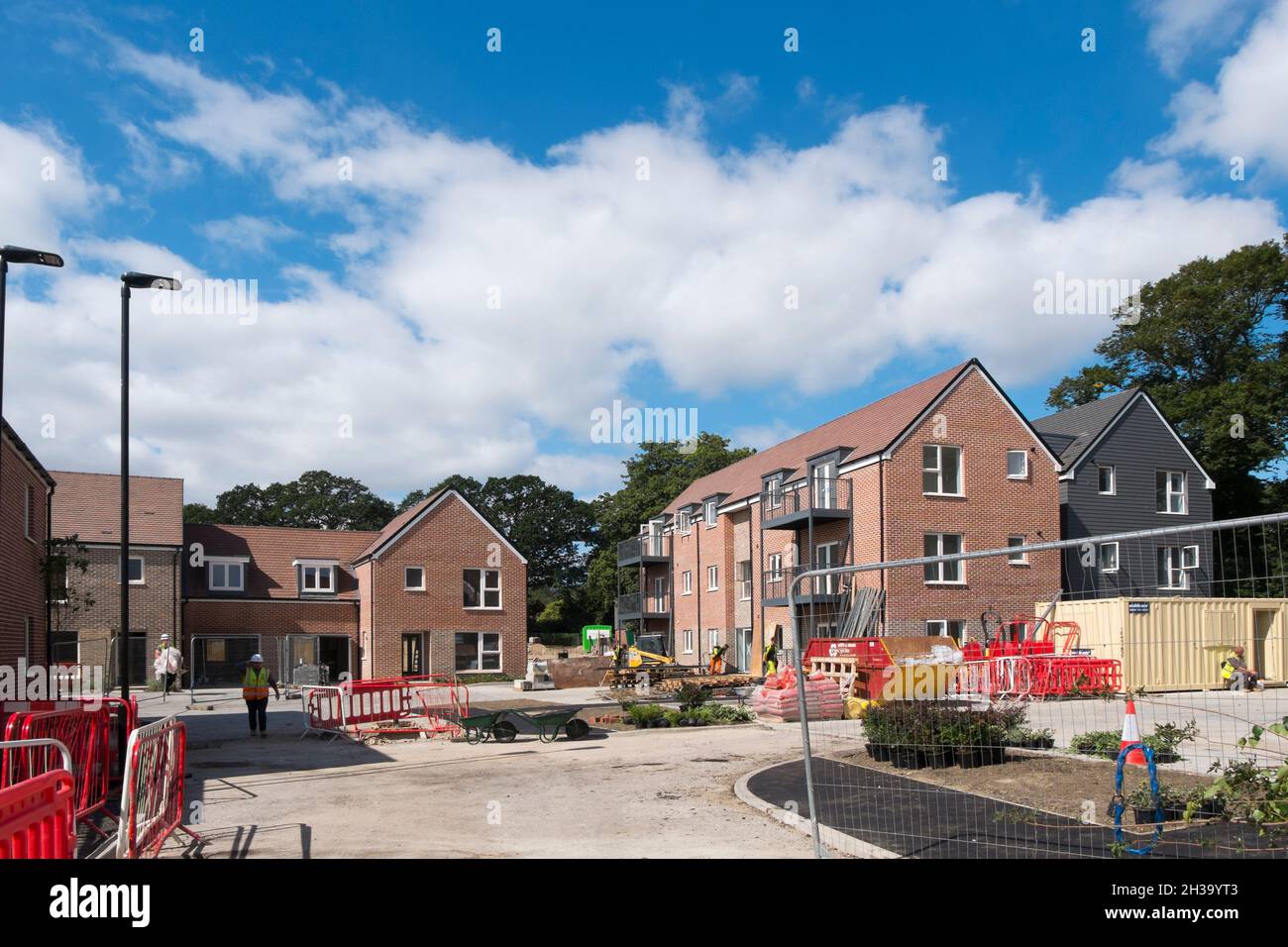 Builders finishing the flats, houses and roads at Keepers Green, the new development in north Chichester, West Sussex, England, UK. Stock Photo