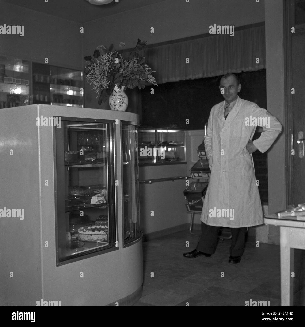 Ein junger Mann an der Theke seiner Konditorei, Deutschland 1950er Jahre. A young man at the counter of his cafe, Germany 1950s. Stock Photo
