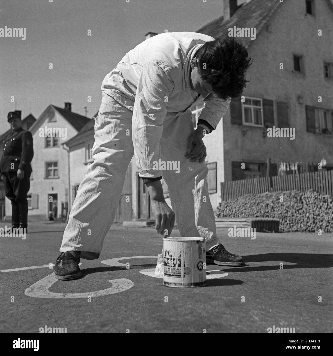 Ein Malermeister bei der Bezeichung von Parkplätzen auf der Straße, Deutschland 1950er Jahre. A painter marking parking areas on the street, Germany 1950s. Stock Photo