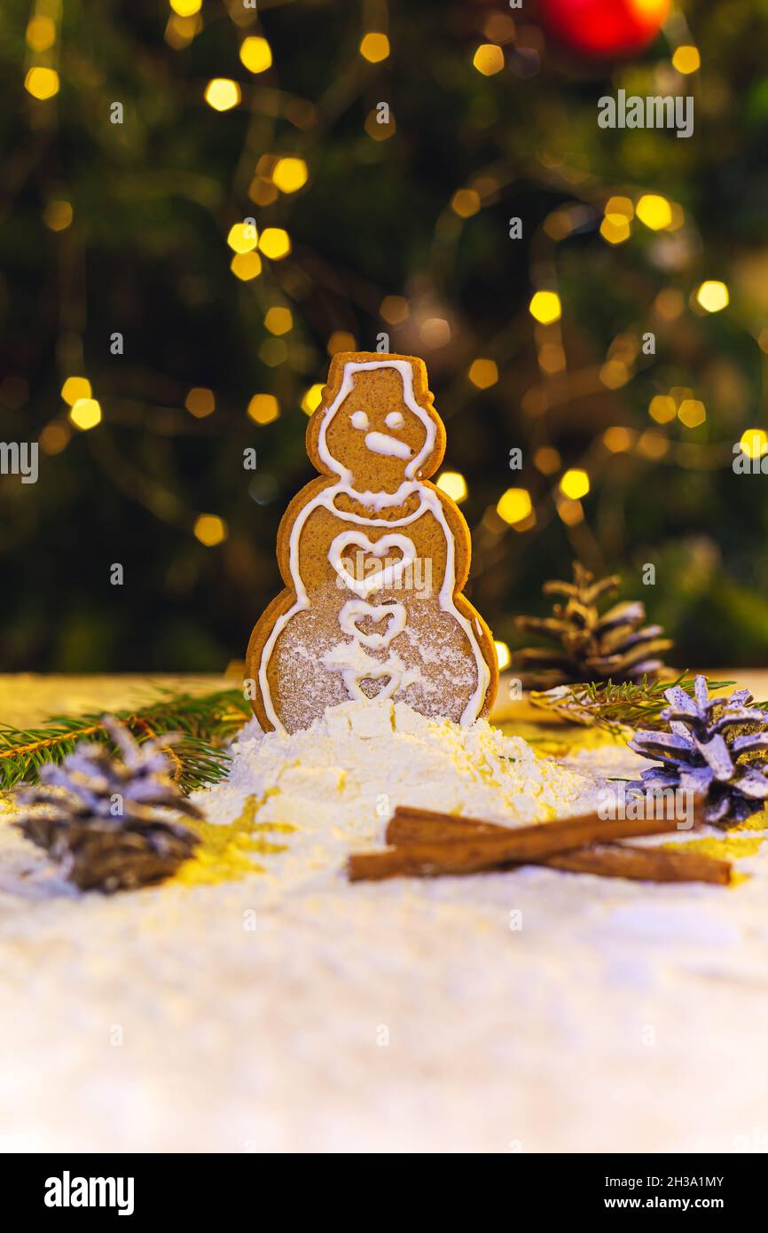 Christmas gingerbread on the background of a  tree with a garland. New Year or Christmas food background. Stock Photo