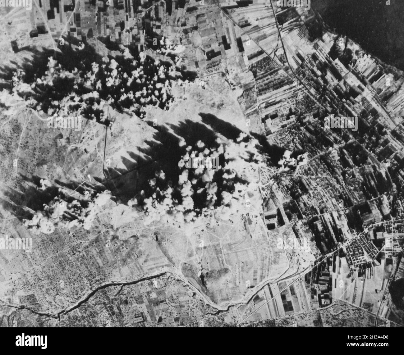 Nazi held Greek Airfield raided. Administrations buildings, hangars, and Revetments are covered by bomb bursts during the raid on the Eleusis Airfield, twenty two kilometers north of Athens, Greece by B-17 Flying Fortresses of the United States Air Force Stock Photo