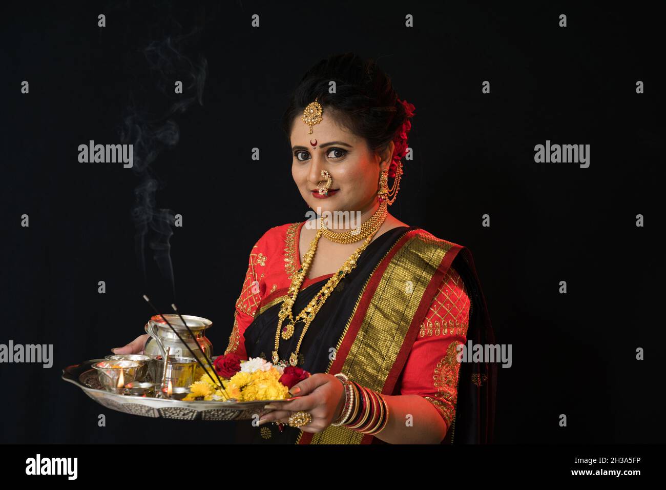 Indian Marathi Woman in sari celebrating Diwali. Holding Diya or Lamps for Puja worship Stock Photo