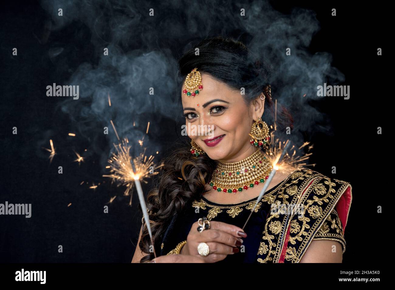 Indian Marathi Woman in sari celebrating Diwali. Holding lit fire works in hands Stock Photo