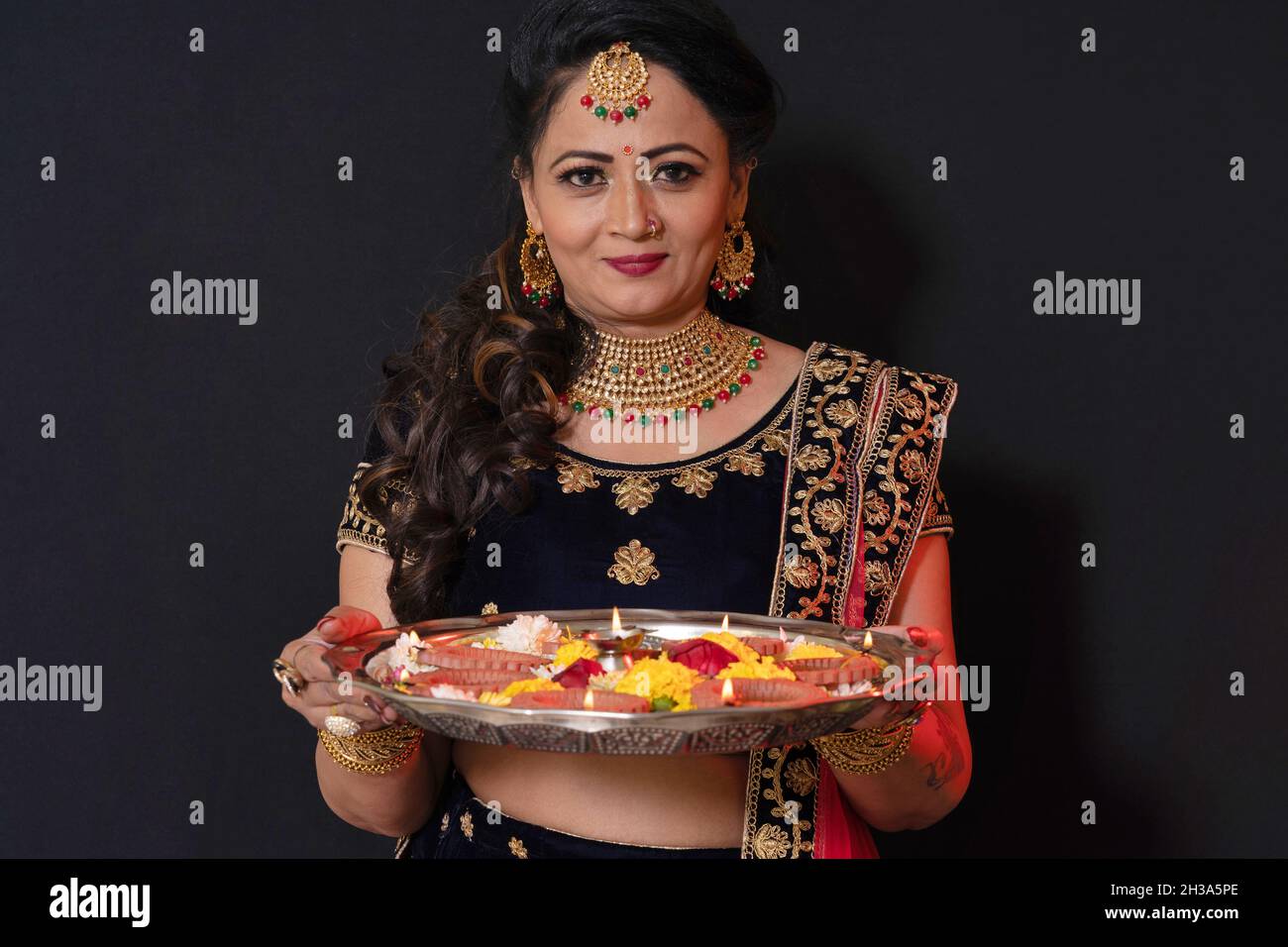 Indian Marathi Woman in sari celebrating Diwali. Holding Puja tray with flowers fro worship Stock Photo