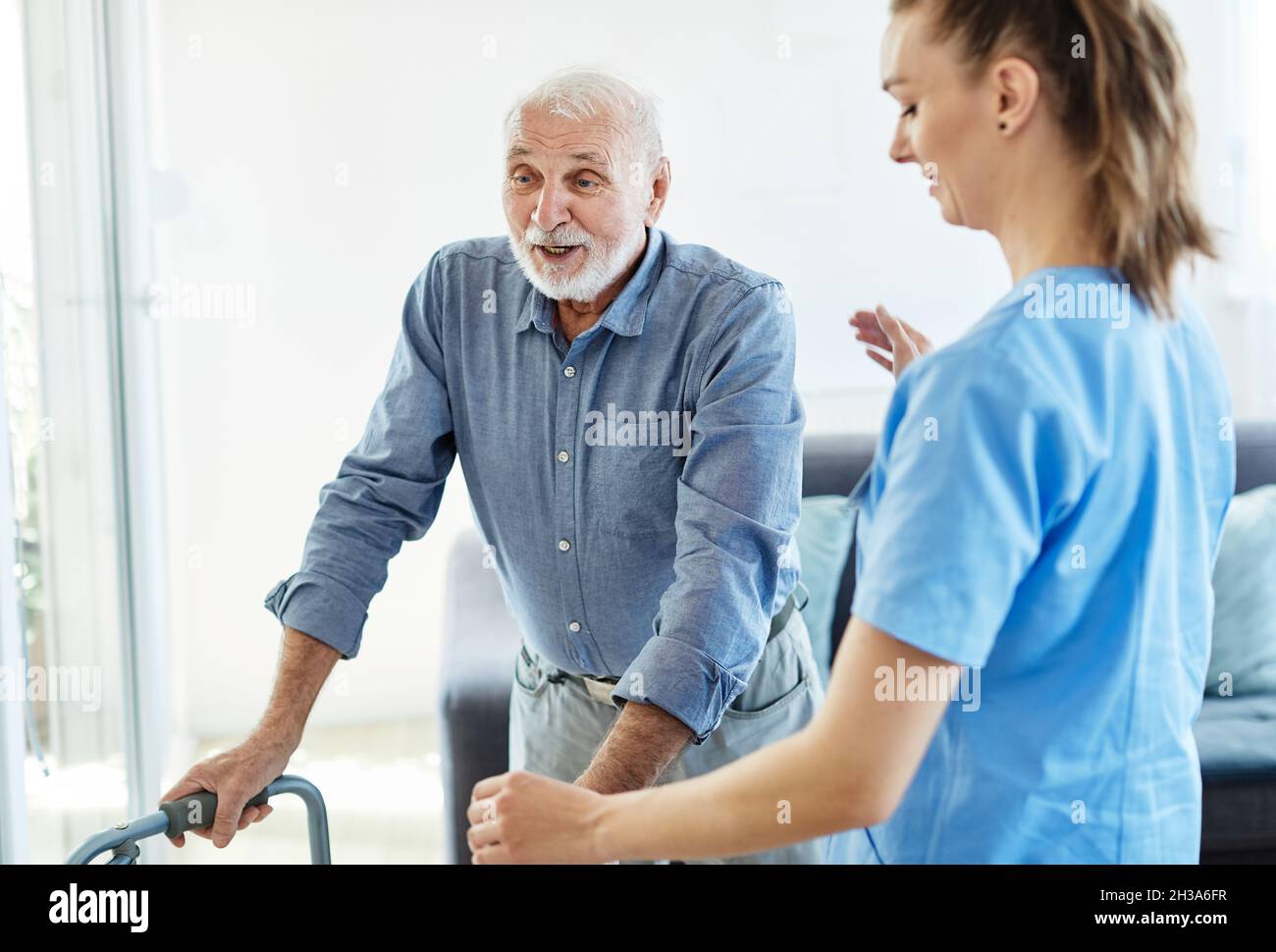 nurse doctor senior care caregiver help walker assistence retirement home nursing elderly man Stock Photo