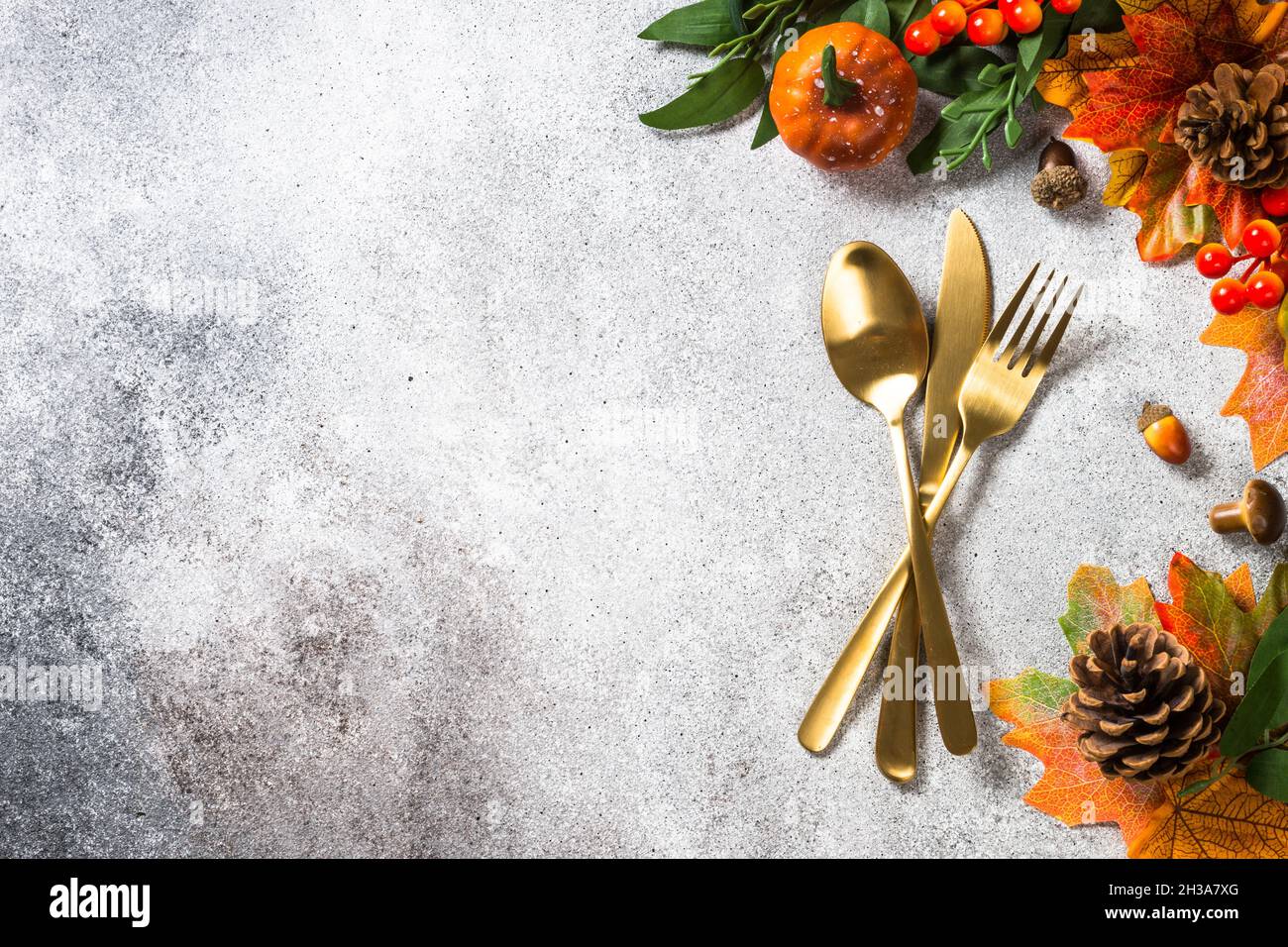 Gold cutlery and autumn decorations at stone kitchen table Stock Photo ...