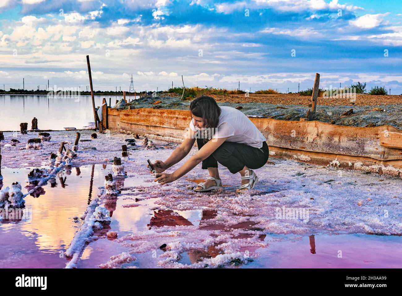A young woman takes pictures on a salt lake Stock Photo