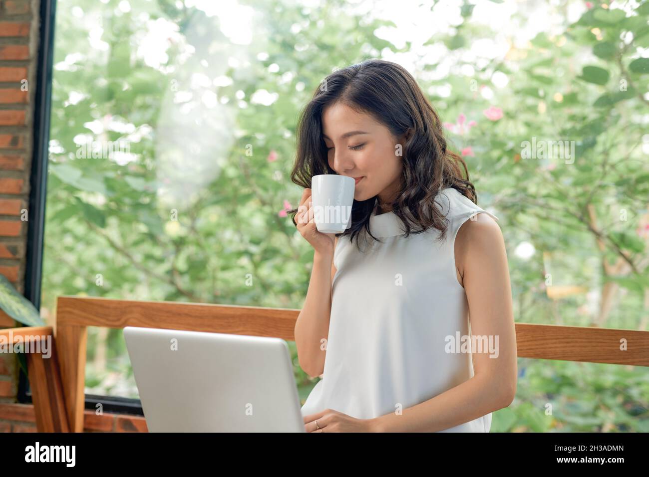 Happy pretty woman using laptop sitting on sofa Stock Photo - Alamy